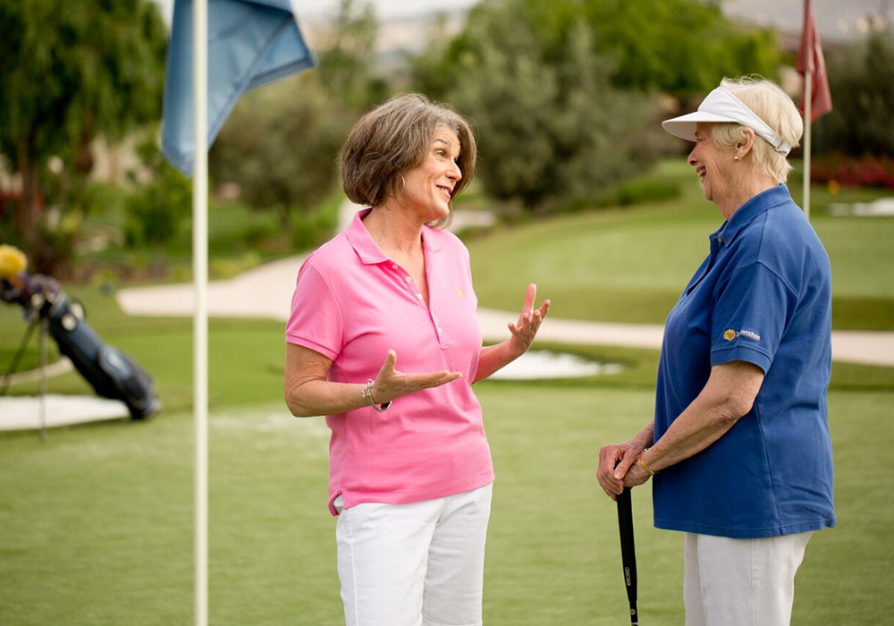 two women talking on a golf course