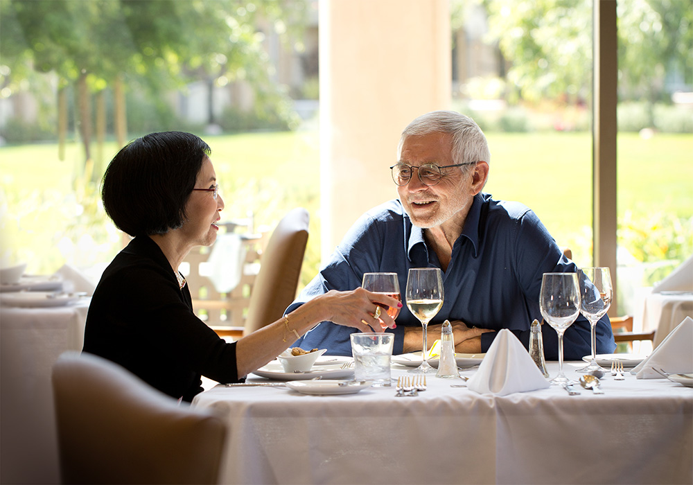 A mature couple dining with linen tablecloths and wine
