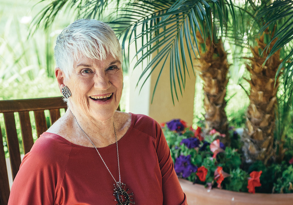 Happy  woman outdoors under a palm tree