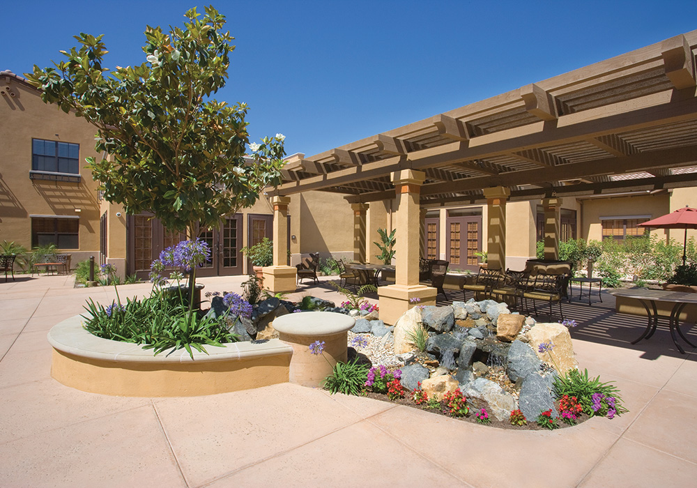 Oakview 1000x700 1 Pergola courtyard with water feature, flowers, and seating
