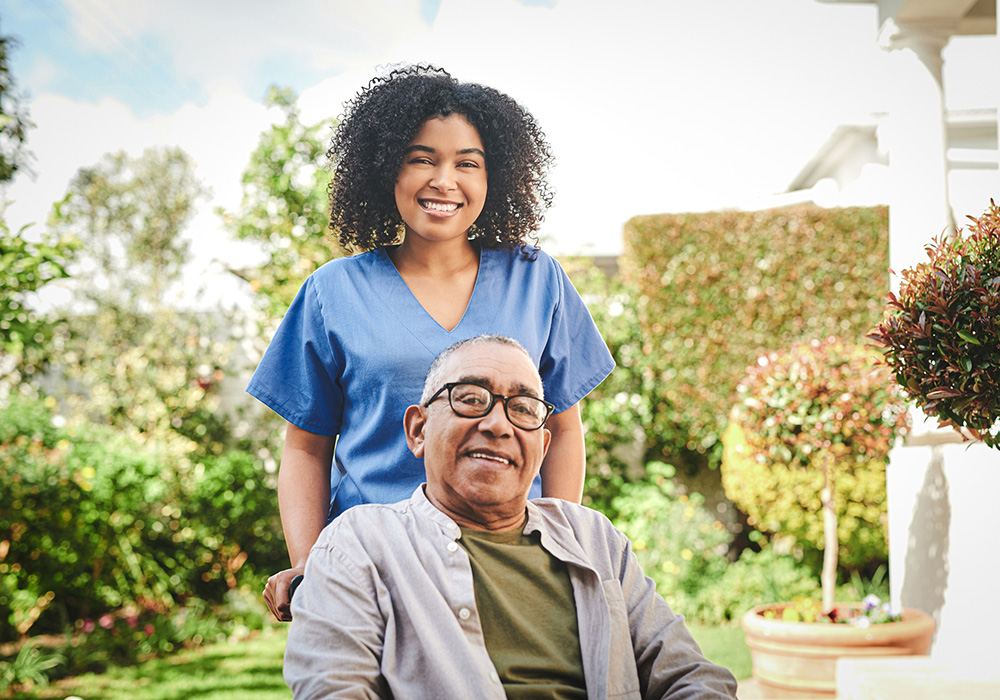 oakview-1000x700-8 African American caregiver pushing the wheelchair of a hispanic elderly man