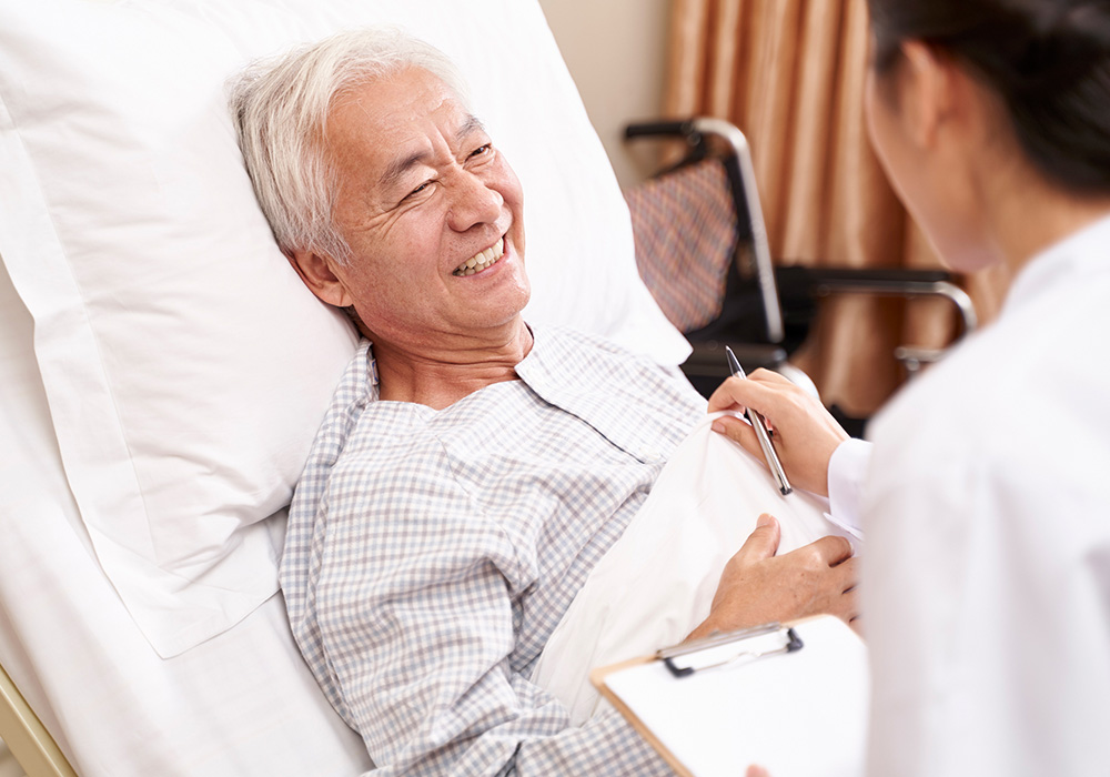 oakview-1000x700-10 A nurse caring for an elderly Asian man propped up in his bed