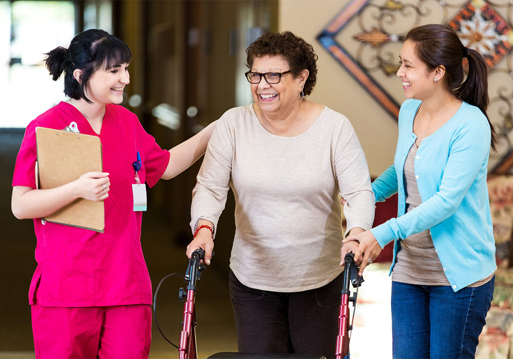 parkvista-1000x700-35 Two healthcare workers helping woman with walker