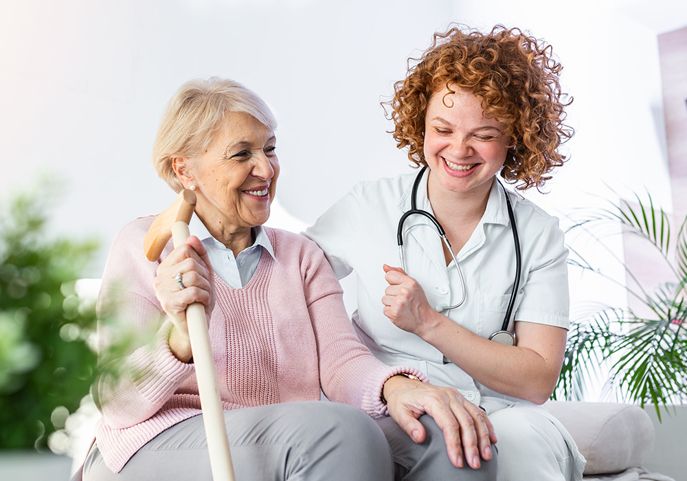 parkvista-1000x700-36 An elderly woman holding a cane, sitting with a caregiver