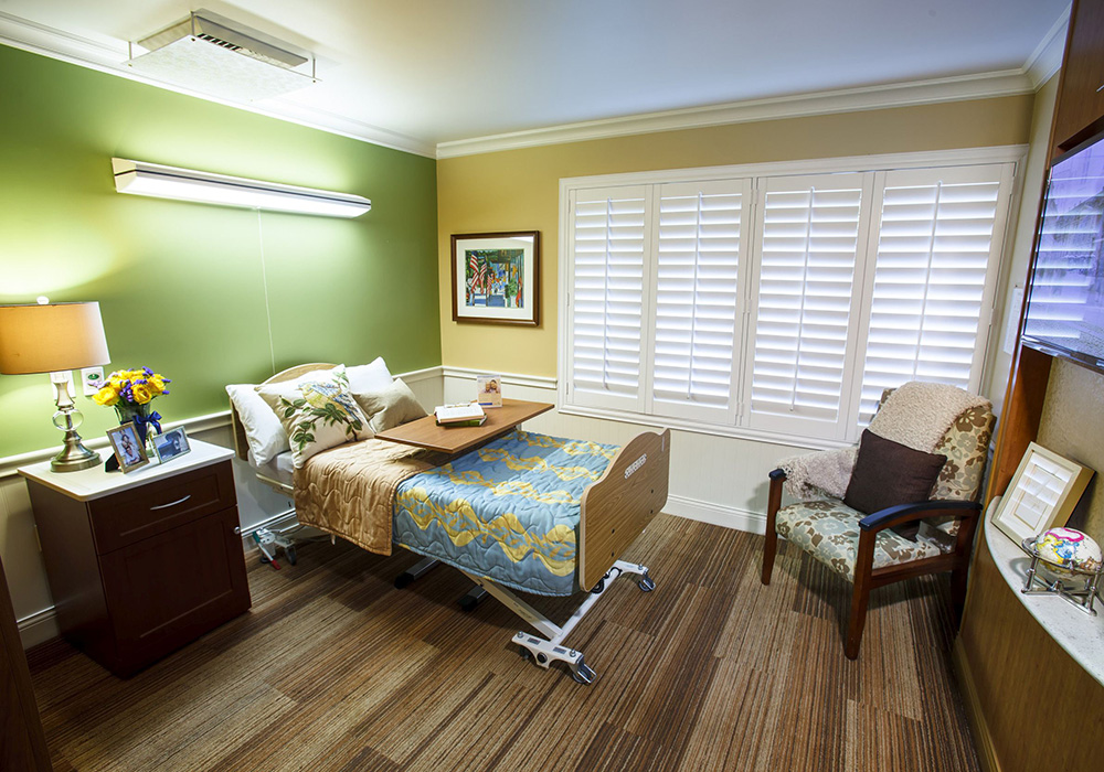 Private room with hospital bed and night stand.