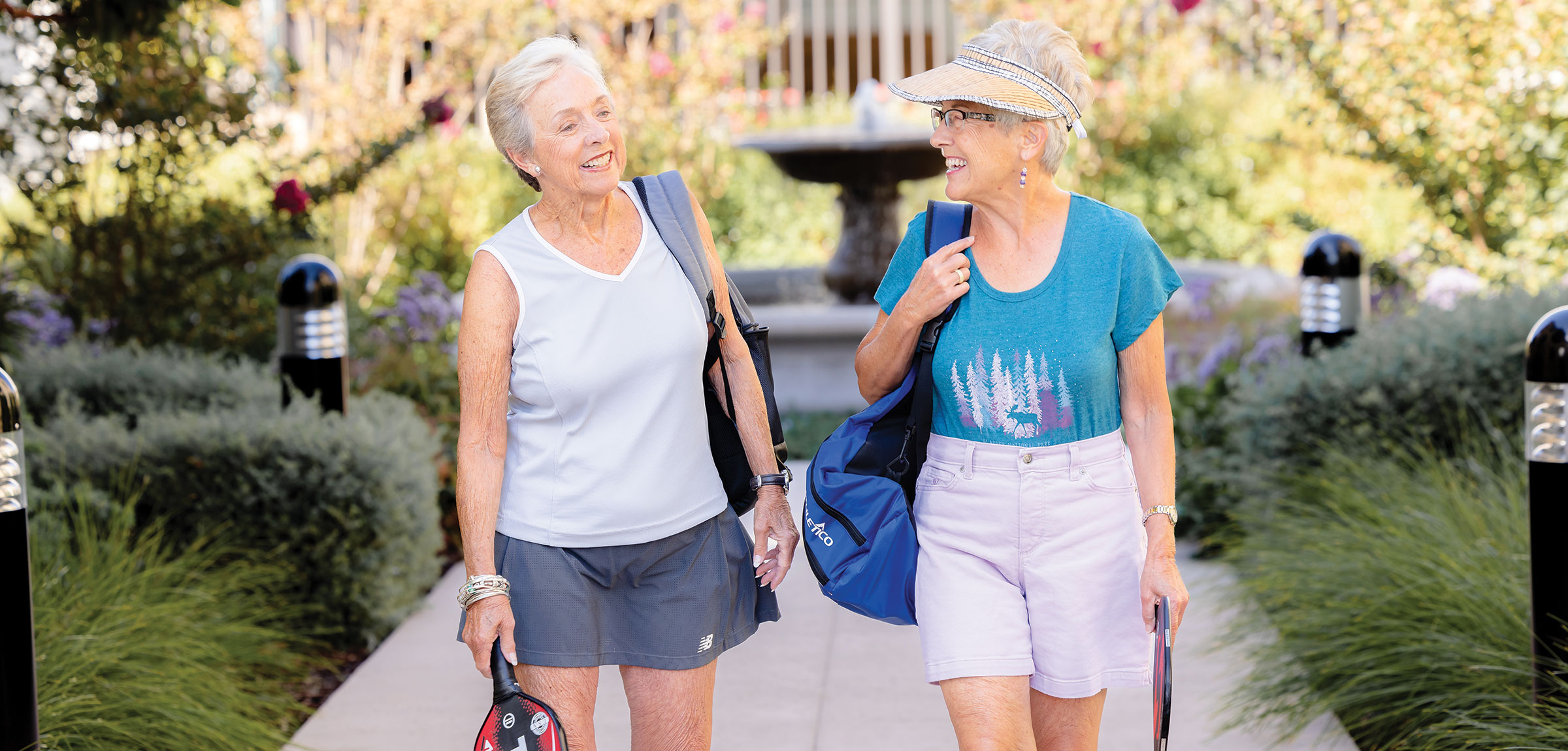 Two women walking to pickleball in their athletic clothing