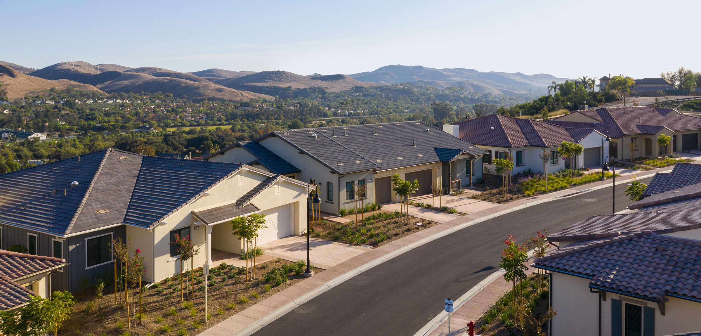 Drone view from above of the front exterior of a few villas at Reata Glen