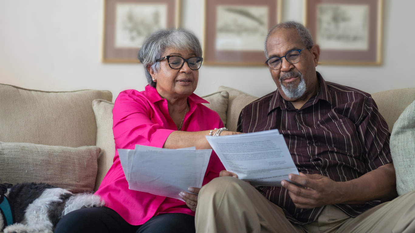 Blog Images (4) A senior man and a senior woman sit side by side and review paperwork together