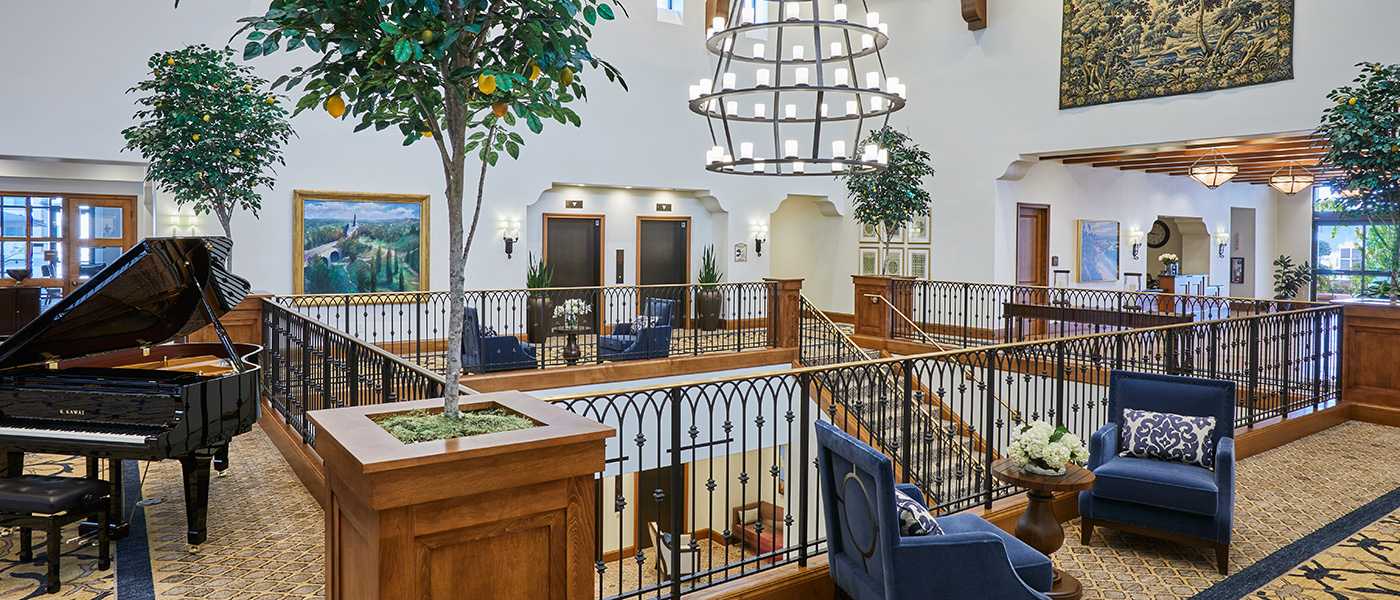 TheGlen-1400x600-9 A common room at The Glen at Scripps Ranch with a piano and plants