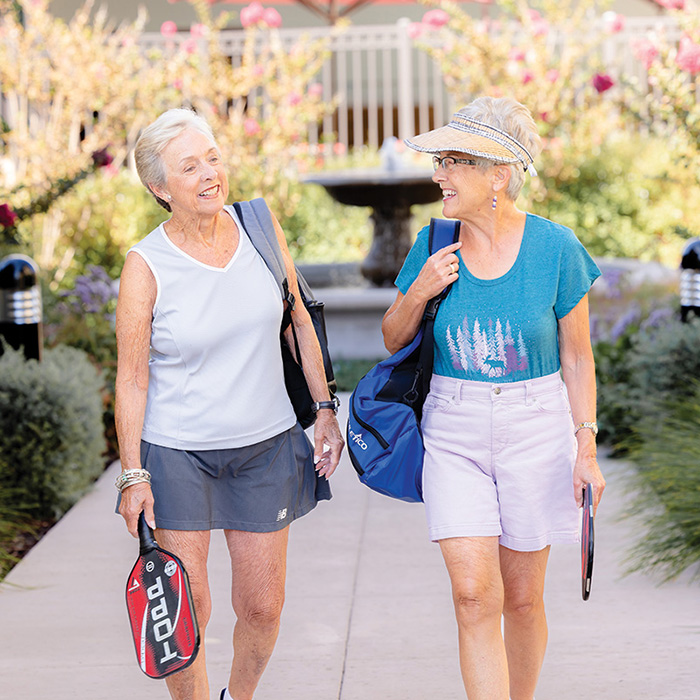 Elderly ladies walking together with sport equipment