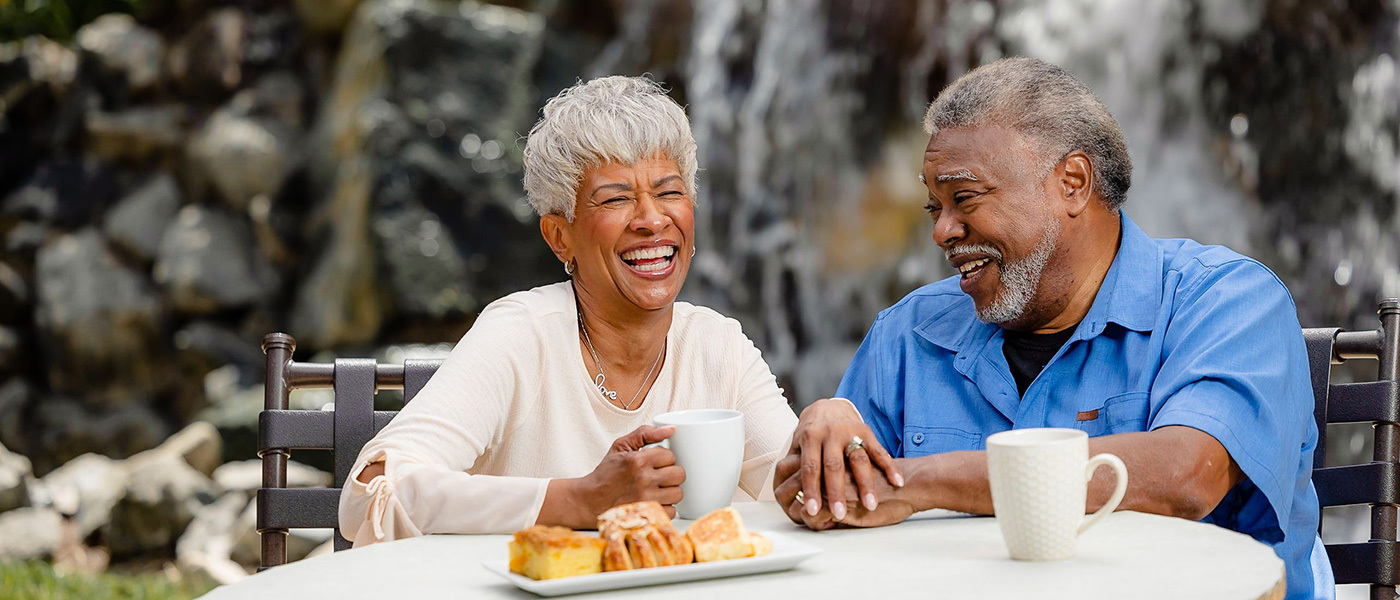 Couple sitting together at a table eating pastries at La Costa Glen