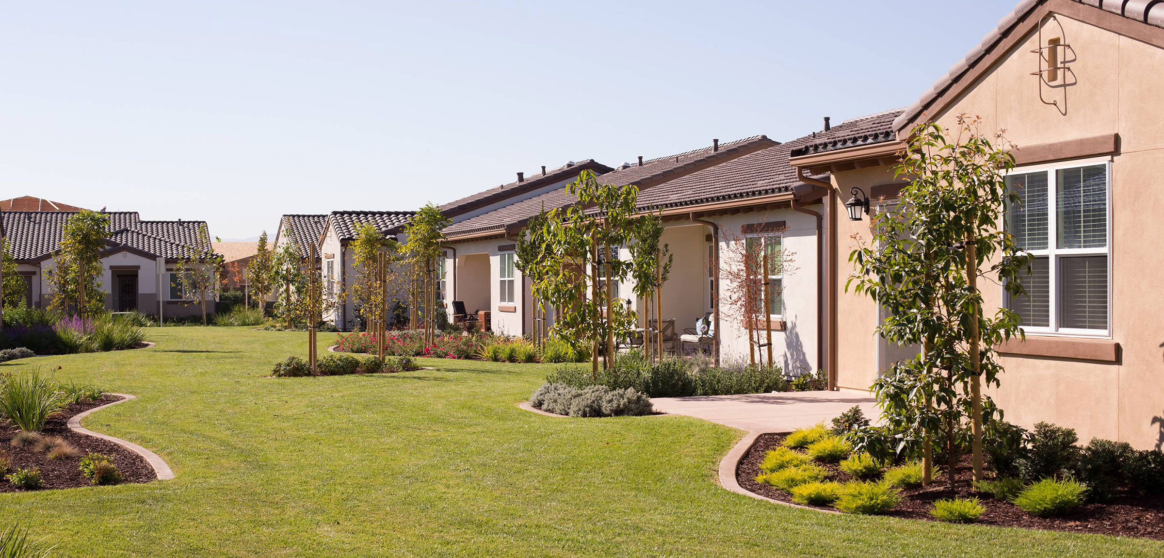 Grassy area next to a row of homes at La Costa Glen