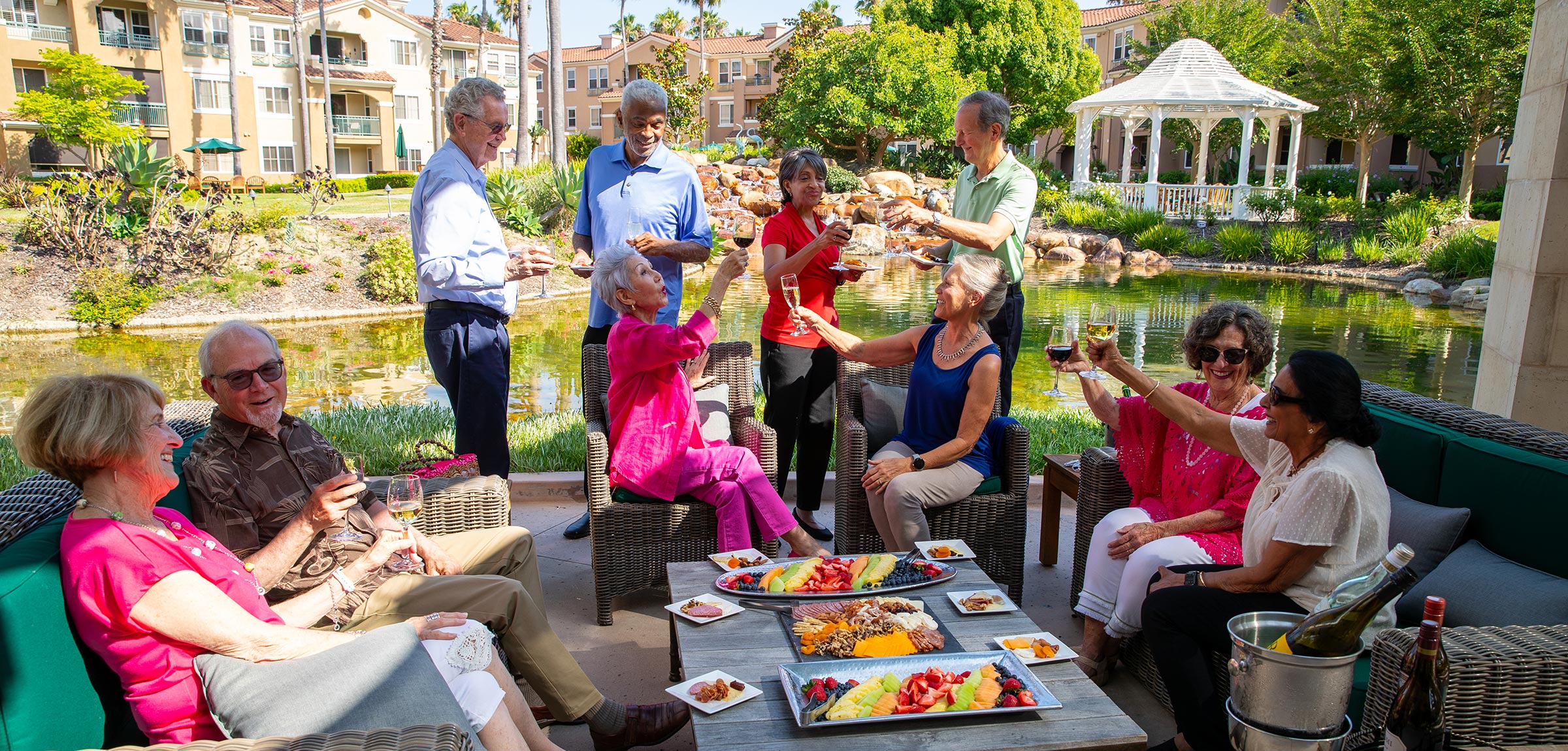 A group of residents chatting and drinking cocktails outdoors