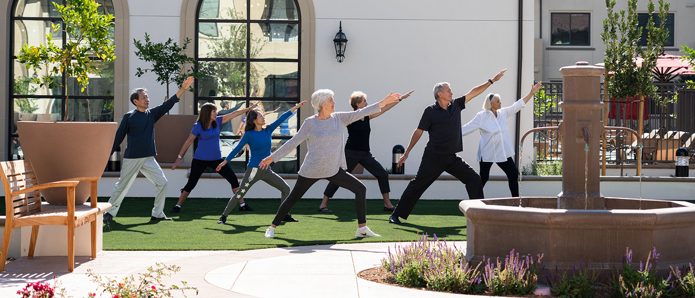 Residences doing yoga in the front of the community