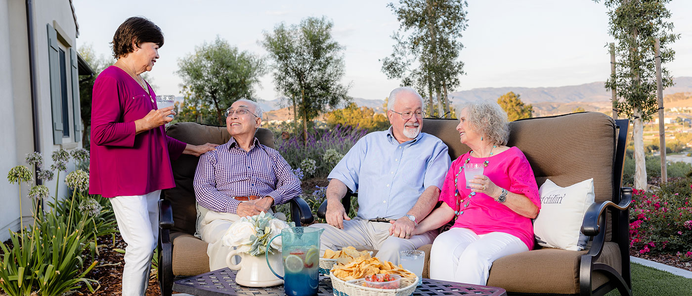 a group of elderly residents sitting outside socializing together