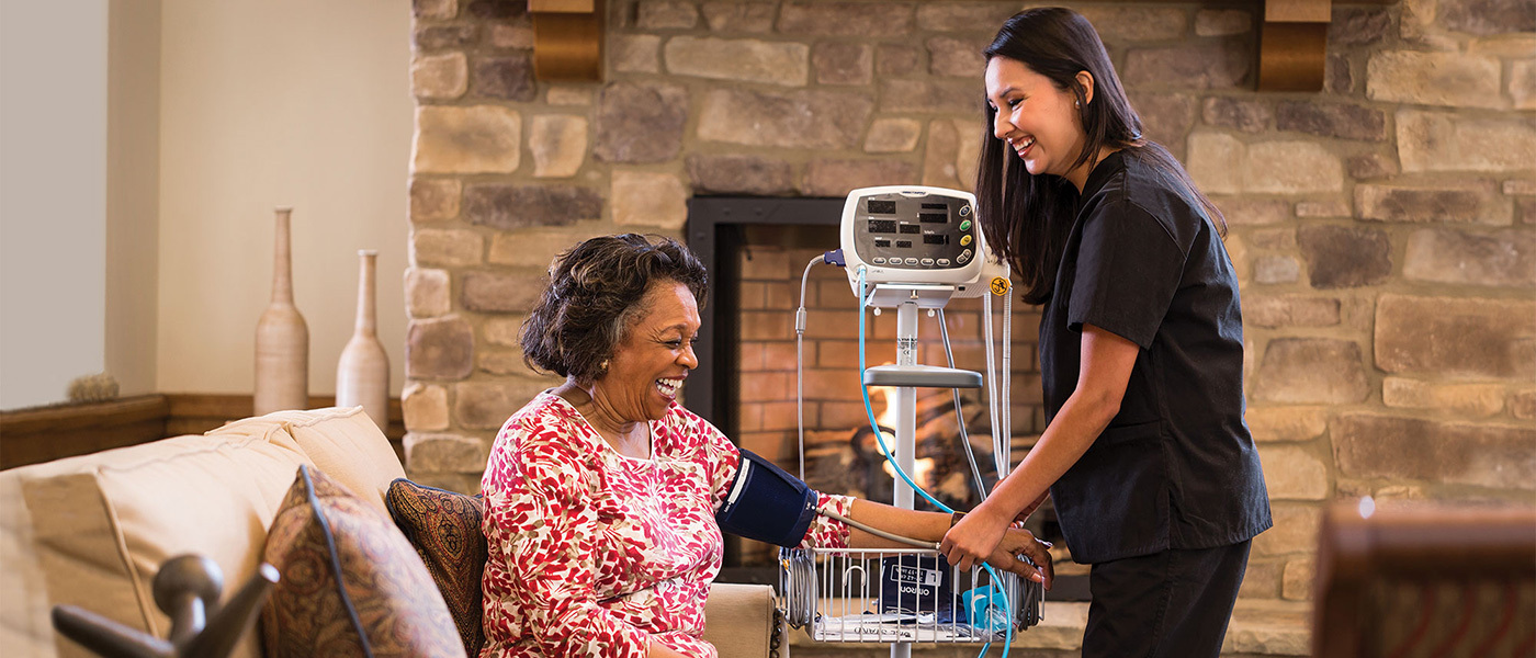 A senior having her vitals checked by a nurse.