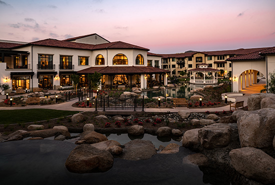 Apartment homes with a water feature in the foreground.