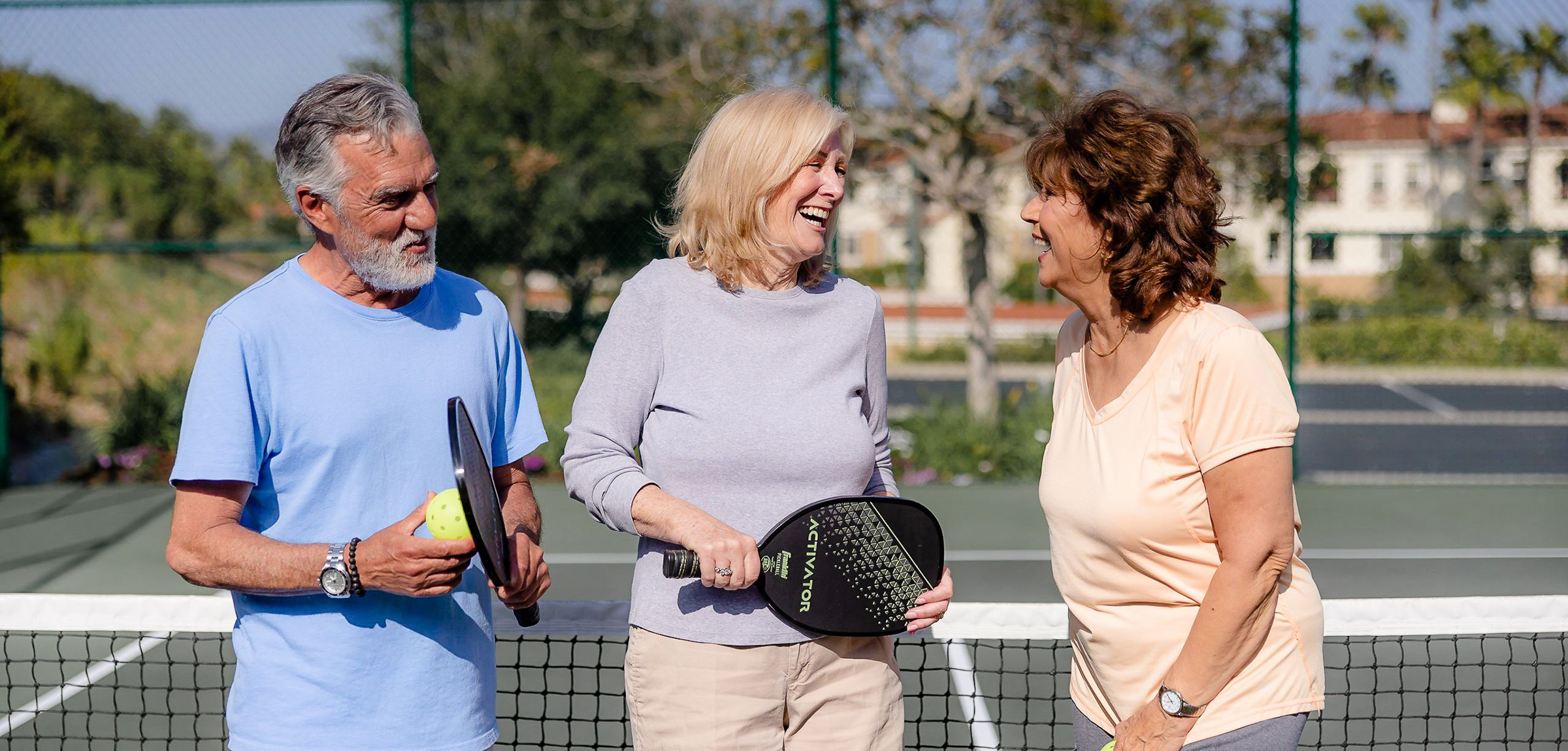 Residents standing together on the pickleball courts