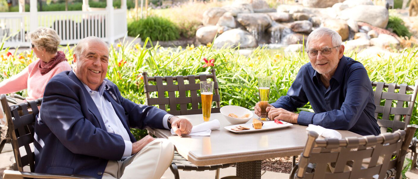 Two men sitting next to each other at a dining table