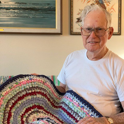 S.O. displaying one of his handmade oval rugs.